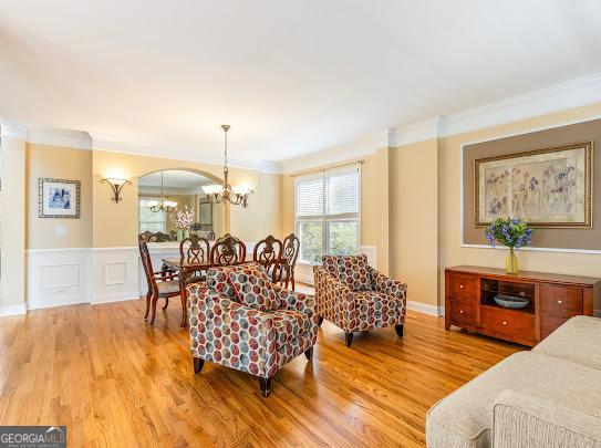 2810 Promenade Pl, Buford, GA 30519 - living room with ornamental molding, a chandelier, and light wood finished floors