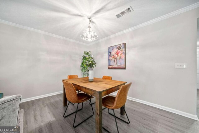 705 Beaufort Cir, Duluth, GA 30096 - dining area with a chandelier, wood finished floors, baseboards, and crown molding