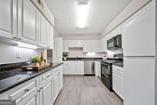 705 Beaufort Cir, Duluth, GA 30096 - kitchen featuring black appliances, white cabinetry, a textured ceiling, light wood finished floors, and a sink