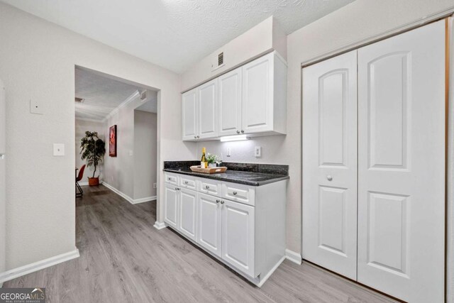 705 Beaufort Cir, Duluth, GA 30096 - kitchen with light wood-style flooring, white cabinets, baseboards, and dark countertops