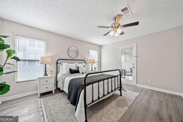 705 Beaufort Cir, Duluth, GA 30096 - bedroom with wood finished floors, a textured ceiling, baseboards, and a ceiling fan