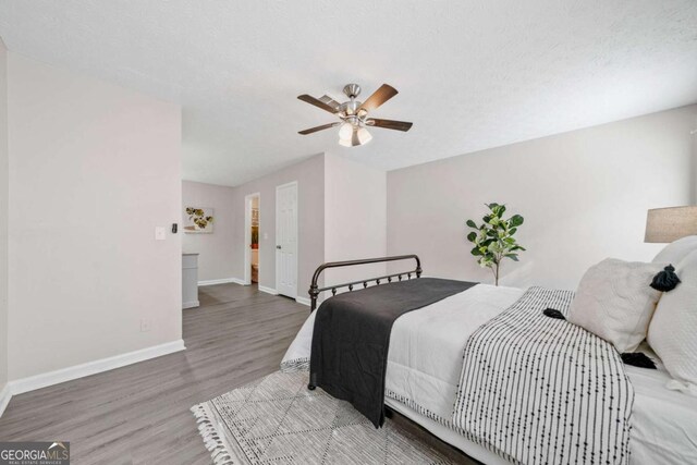 705 Beaufort Cir, Duluth, GA 30096 - bedroom with wood finished floors, baseboards, ceiling fan, and a textured ceiling