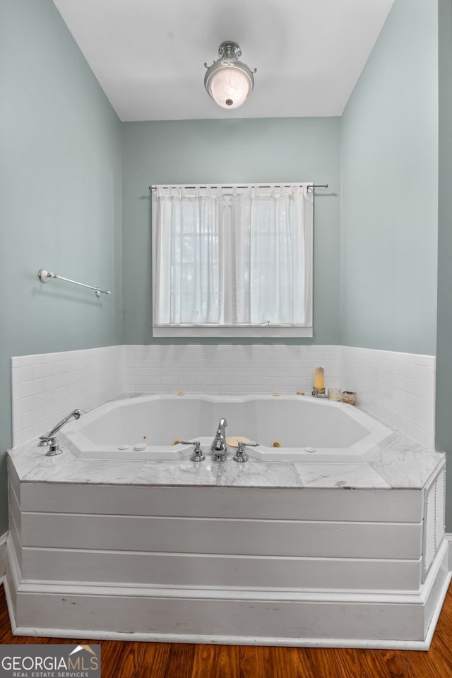 441 Crumbley Rd, Mcdonough, GA 30252 - bathroom featuring a tub with jets and wood finished floors