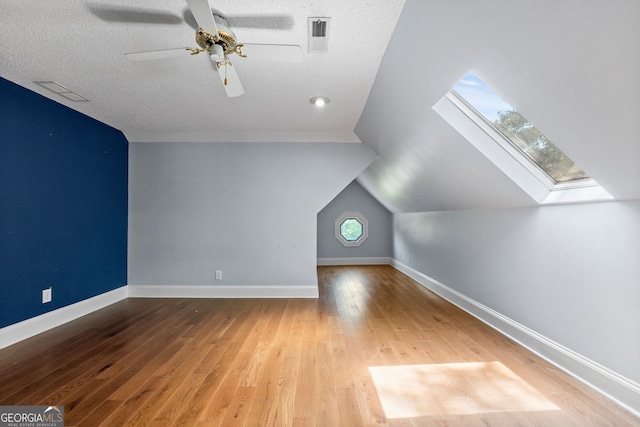 441 Crumbley Rd, Mcdonough, GA 30252 - additional living space featuring a skylight, a ceiling fan, wood finished floors, a textured ceiling, and vaulted ceiling