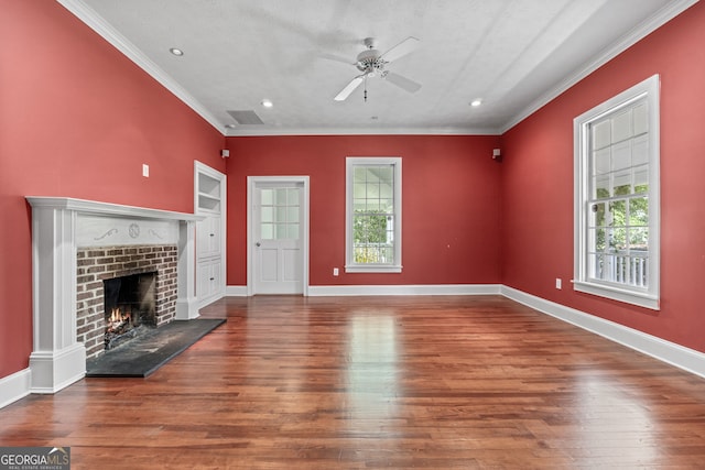 441 Crumbley Rd, Mcdonough, GA 30252 - unfurnished living room with plenty of natural light, ceiling fan, a lit fireplace, ornamental molding, and wood finished floors