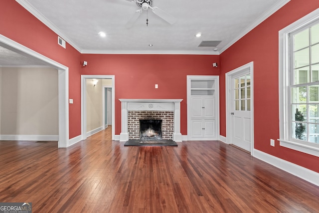 441 Crumbley Rd, Mcdonough, GA 30252 - unfurnished living room with wood finished floors, ornamental molding, a ceiling fan, baseboards, and a brick fireplace