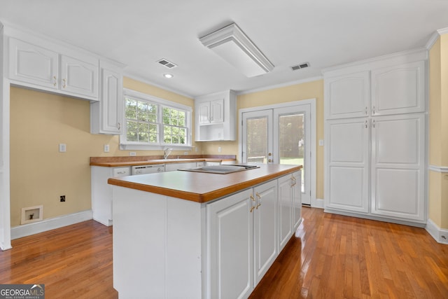 441 Crumbley Rd, Mcdonough, GA 30252 - kitchen featuring white cabinetry, a sink, light wood-style flooring, a kitchen island, and crown molding