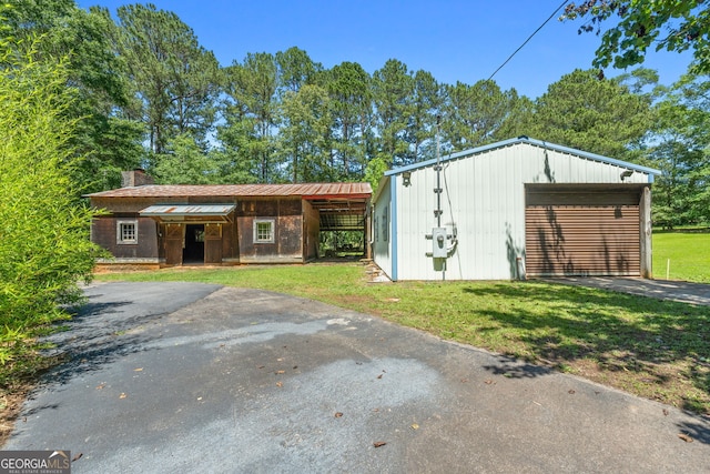 441 Crumbley Rd, Mcdonough, GA 30252 - view of front of house with asphalt driveway, an outdoor structure, a front yard, a chimney, and a garage