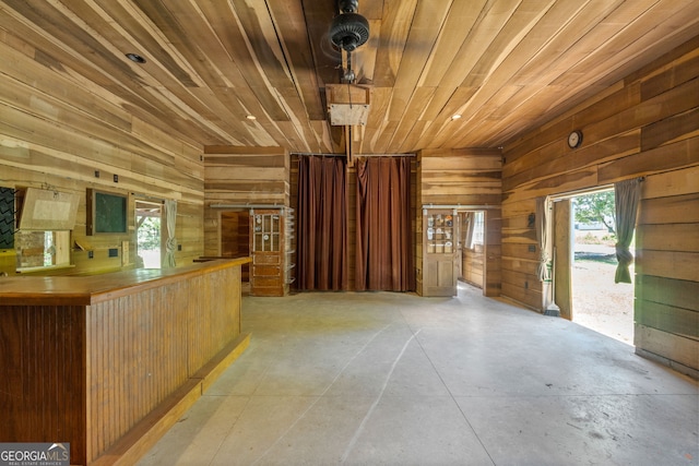 441 Crumbley Rd, Mcdonough, GA 30252 - unfurnished living room with wooden ceiling, wood walls, and concrete flooring