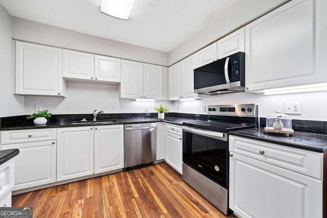 717 Beaufort Cir, Duluth, GA 30096 - kitchen featuring appliances with stainless steel finishes, a sink, and white cabinets