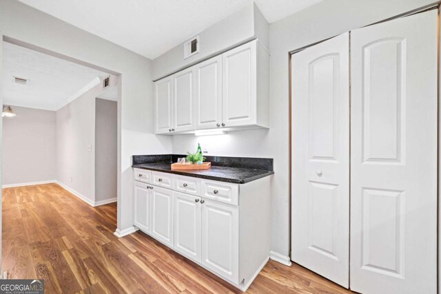 717 Beaufort Cir, Duluth, GA 30096 - kitchen with dark countertops, white cabinetry, light wood-type flooring, and baseboards