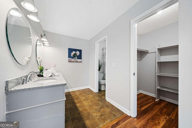 717 Beaufort Cir, Duluth, GA 30096 - full bath featuring toilet, a spacious closet, vanity, and baseboards