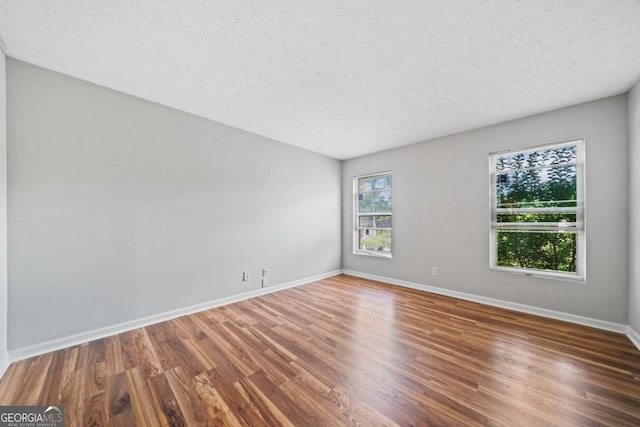 717 Beaufort Cir, Duluth, GA 30096 - unfurnished room with wood finished floors, a textured ceiling, and baseboards