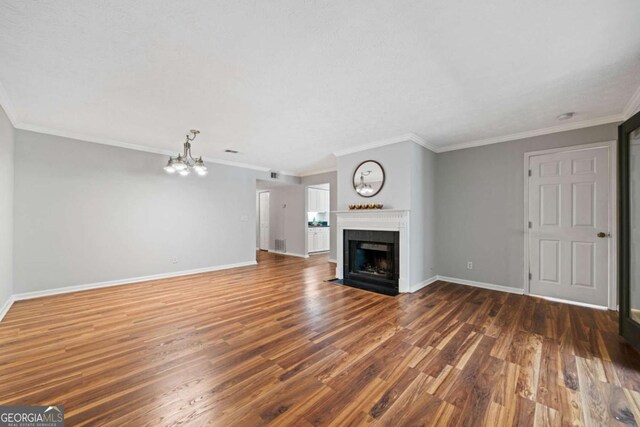 717 Beaufort Cir, Duluth, GA 30096 - unfurnished living room featuring wood finished floors, baseboards, a chandelier, a fireplace with flush hearth, and ornamental molding