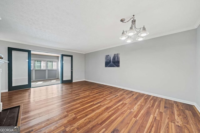 717 Beaufort Cir, Duluth, GA 30096 - empty room with baseboards, ornamental molding, wood finished floors, a chandelier, and a textured ceiling