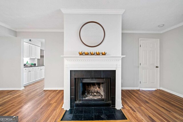 717 Beaufort Cir, Duluth, GA 30096 - detailed view of a tiled fireplace, wood finished floors, baseboards, and crown molding