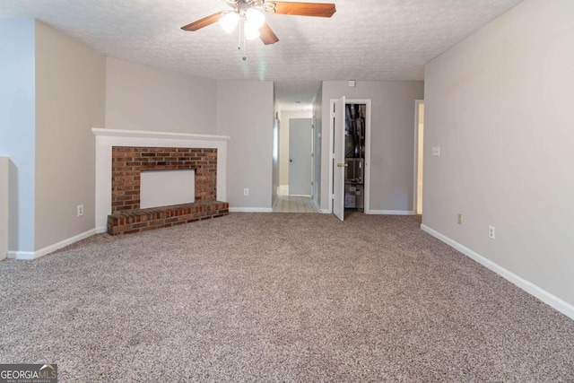 5614 Regency Forest Ct, Lithonia, GA 30038 - unfurnished living room with ceiling fan, a textured ceiling, carpet, baseboards, and a brick fireplace