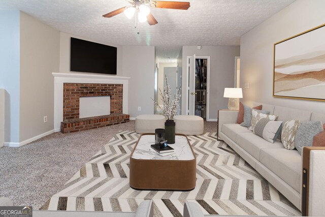 5614 Regency Forest Ct, Lithonia, GA 30038 - living room with a textured ceiling, carpet, ceiling fan, baseboards, and a fireplace