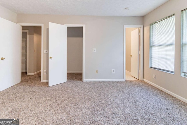 5614 Regency Forest Ct, Lithonia, GA 30038 - unfurnished bedroom with a spacious closet, carpet floors, and baseboards