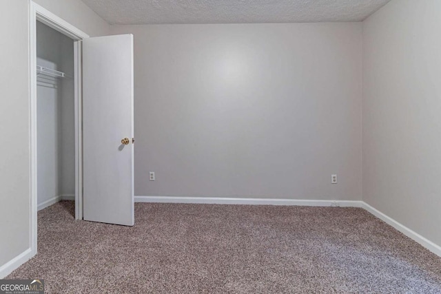 5614 Regency Forest Ct, Lithonia, GA 30038 - unfurnished bedroom featuring carpet floors, a textured ceiling, baseboards, and a closet