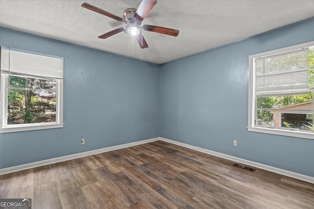 423 Clifton Ter, Carrollton, GA 30117 - unfurnished room featuring a textured ceiling, healthy amount of natural light, dark wood-type flooring, and a ceiling fan
