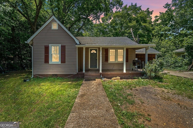 423 Clifton Ter, Carrollton, GA 30117 - view of front of house featuring covered porch, a lawn, a shingled roof, and view of wooded area