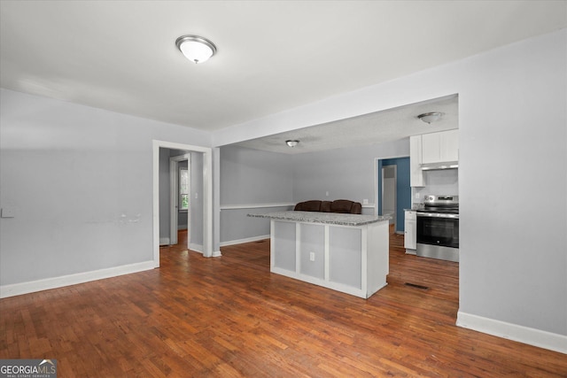 423 Clifton Ter, Carrollton, GA 30117 - kitchen with electric stove, under cabinet range hood, white cabinetry, dark wood-type flooring, and a kitchen island