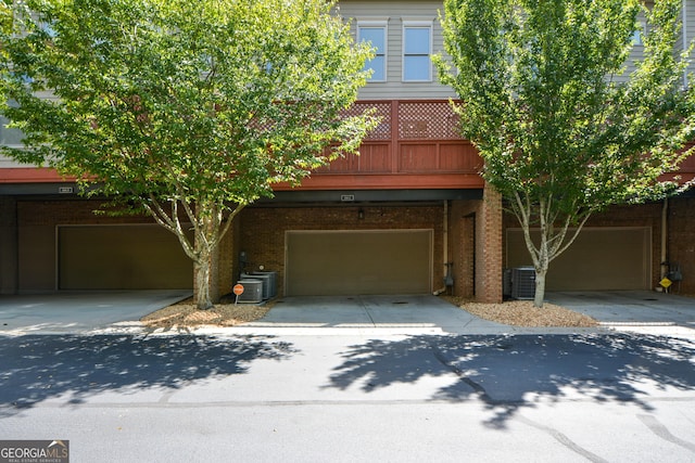 661 Lockton Pl # 9, Sandy Springs, GA 30342 - view of front of home featuring driveway, an attached garage, brick siding, and central AC
