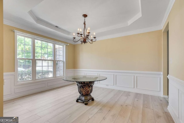 543 Serene Waters Trl, Jonesboro, GA 30236 - dining area featuring a raised ceiling, a chandelier, wainscoting, light wood-style floors, and ornamental molding