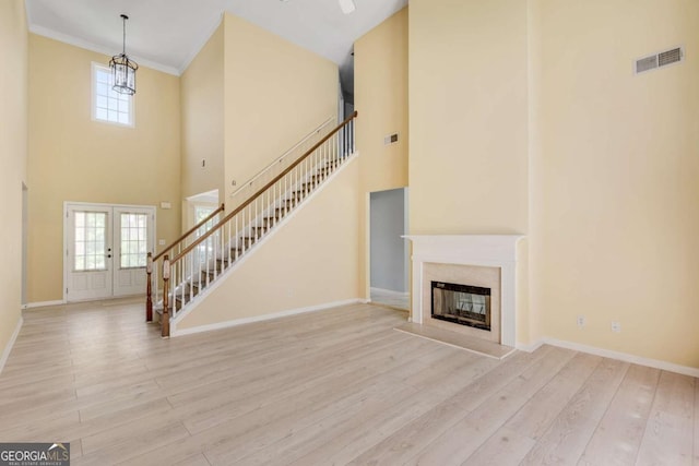 543 Serene Waters Trl, Jonesboro, GA 30236 - unfurnished living room featuring stairs, a towering ceiling, wood finished floors, plenty of natural light, and a fireplace