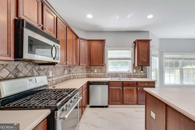 543 Serene Waters Trl, Jonesboro, GA 30236 - kitchen featuring appliances with stainless steel finishes, a sink, light marble finish flooring, tasteful backsplash, and light countertops