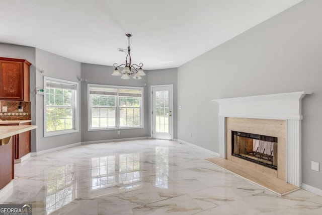543 Serene Waters Trl, Jonesboro, GA 30236 - unfurnished living room with light marble finish flooring, healthy amount of natural light, a chandelier, and a fireplace