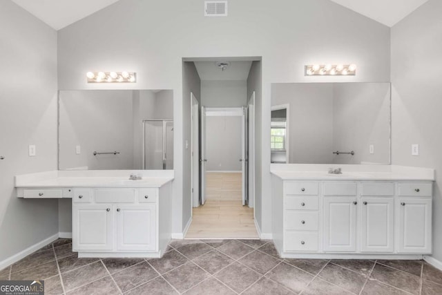 543 Serene Waters Trl, Jonesboro, GA 30236 - bathroom with lofted ceiling, two vanities, a shower stall, and baseboards