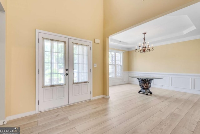 543 Serene Waters Trl, Jonesboro, GA 30236 - entrance foyer featuring french doors, wood finished floors, a chandelier, a wainscoted wall, and crown molding