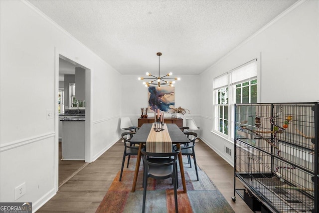 1359 Chatley Way, Woodstock, GA 30188 - dining room with a chandelier, dark wood-style floors, ornamental molding, a textured ceiling, and baseboards