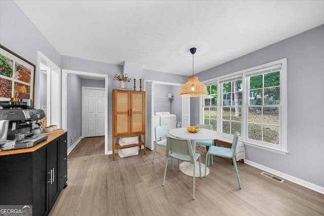 1359 Chatley Way, Woodstock, GA 30188 - dining space featuring washing machine and clothes dryer, light wood-style floors, and baseboards