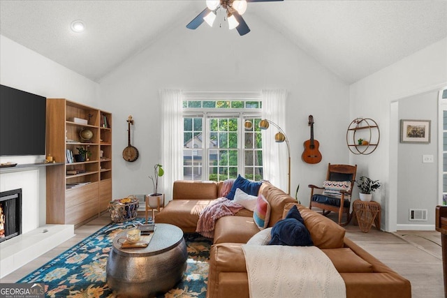 1359 Chatley Way, Woodstock, GA 30188 - living room with a ceiling fan, a lit fireplace, high vaulted ceiling, and light wood finished floors