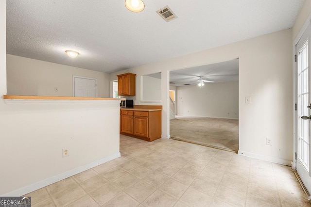85 Old Gettysburg Way, Dallas, GA 30157 - kitchen with ceiling fan, brown cabinets, baseboards, light countertops, and open floor plan