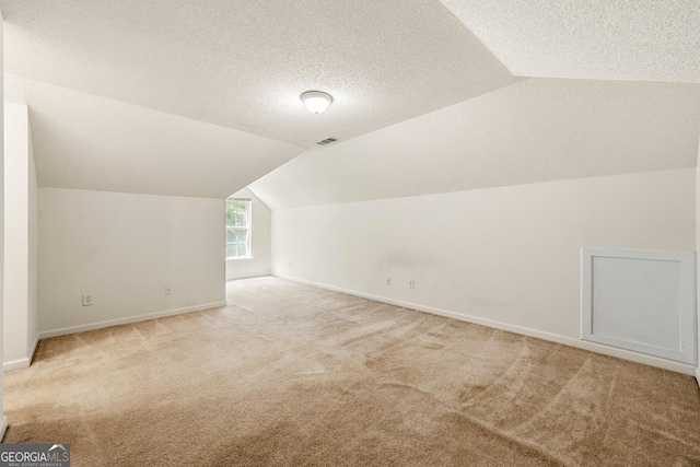 85 Old Gettysburg Way, Dallas, GA 30157 - bonus room with lofted ceiling, light carpet, baseboards, and a textured ceiling