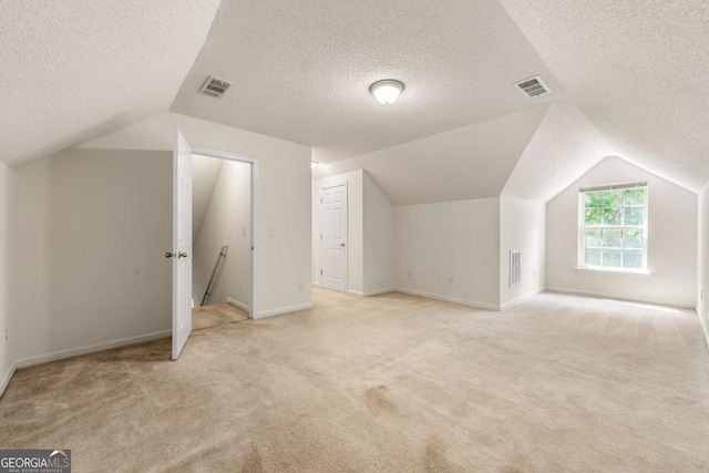 85 Old Gettysburg Way, Dallas, GA 30157 - additional living space with lofted ceiling, light carpet, a textured ceiling, and baseboards
