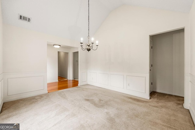 85 Old Gettysburg Way, Dallas, GA 30157 - unfurnished dining area with carpet floors, a chandelier, wainscoting, a decorative wall, and high vaulted ceiling