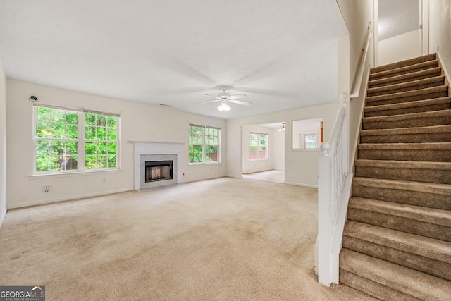85 Old Gettysburg Way, Dallas, GA 30157 - unfurnished living room featuring a ceiling fan, light carpet, a fireplace, and stairs