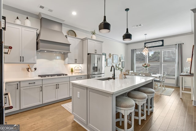 485 Delaperriere Loop, Jefferson, GA 30549 - kitchen with appliances with stainless steel finishes, wall chimney exhaust hood, an island with sink, light countertops, and tasteful backsplash