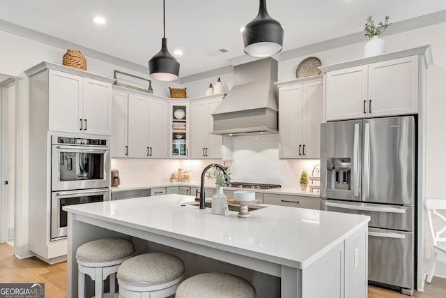 485 Delaperriere Loop, Jefferson, GA 30549 - kitchen with stainless steel appliances, custom exhaust hood, backsplash, pendant lighting, and a kitchen island with sink