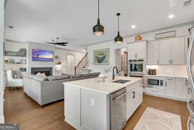 485 Delaperriere Loop, Jefferson, GA 30549 - kitchen with appliances with stainless steel finishes, ceiling fan, light countertops, a center island with sink, and backsplash
