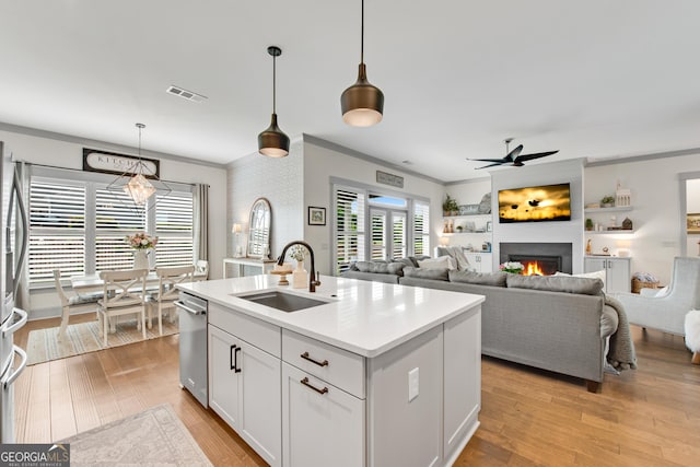 485 Delaperriere Loop, Jefferson, GA 30549 - kitchen with appliances with stainless steel finishes, crown molding, ceiling fan, a warm lit fireplace, and light countertops