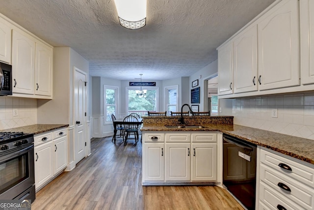 1882 Flowering Dr, Grayson, GA 30017 - kitchen featuring dishwasher, a sink, stainless steel gas range oven, light wood-type flooring, and a textured ceiling