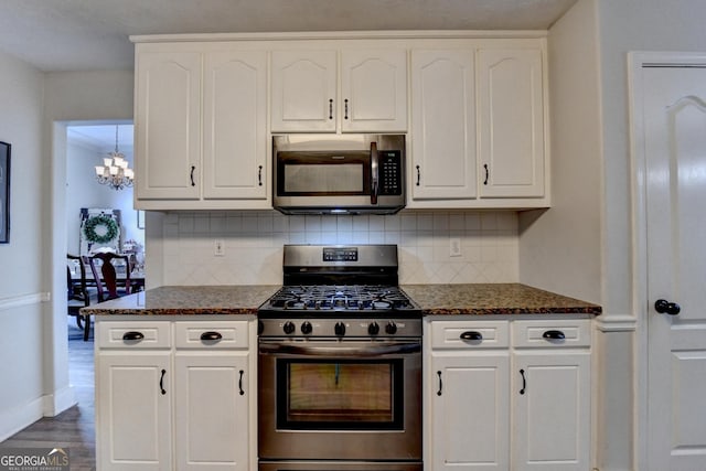 1882 Flowering Dr, Grayson, GA 30017 - kitchen with appliances with stainless steel finishes, a chandelier, decorative backsplash, and white cabinets