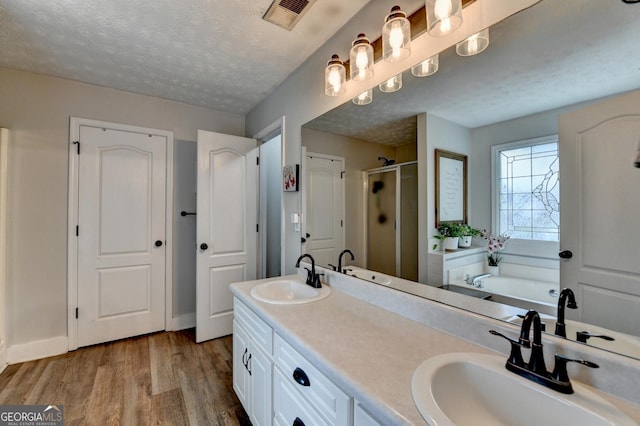 1882 Flowering Dr, Grayson, GA 30017 - bathroom with a shower stall, a garden tub, wood finished floors, and double vanity