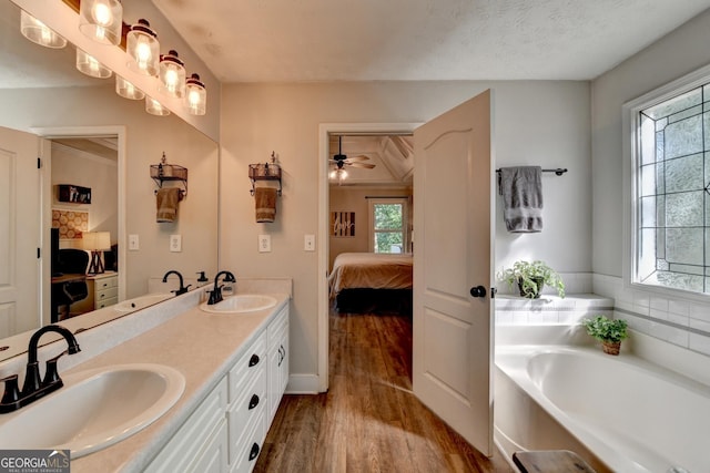 1882 Flowering Dr, Grayson, GA 30017 - ensuite bathroom featuring wood finished floors, healthy amount of natural light, double vanity, and a bath